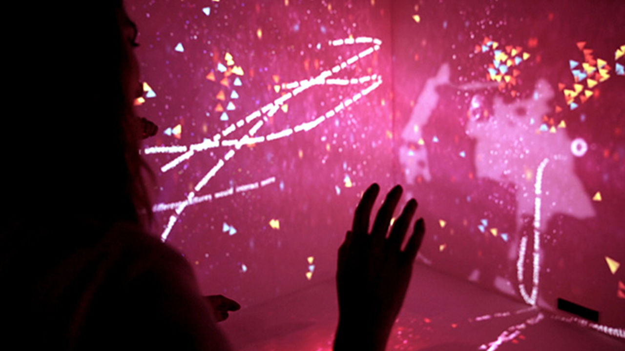 People interacting with full-room projections as part of the installation.
