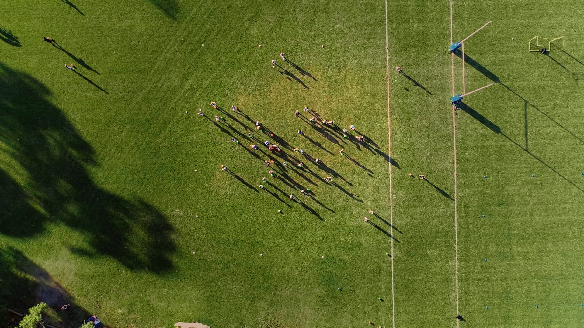 Aerial top-down shot of people playing on a sporting field.