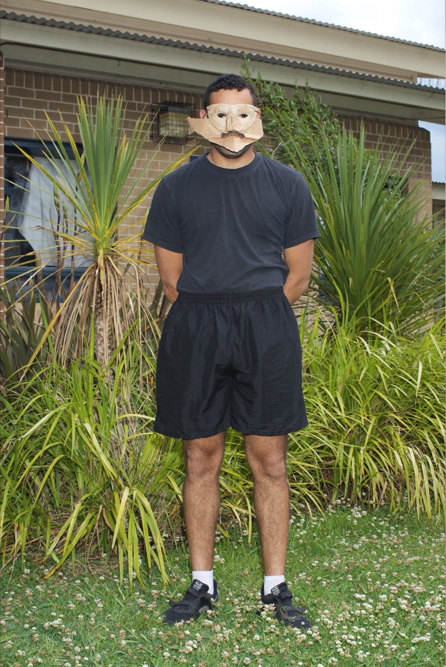 Full-shot of man wearing cardboard mask.