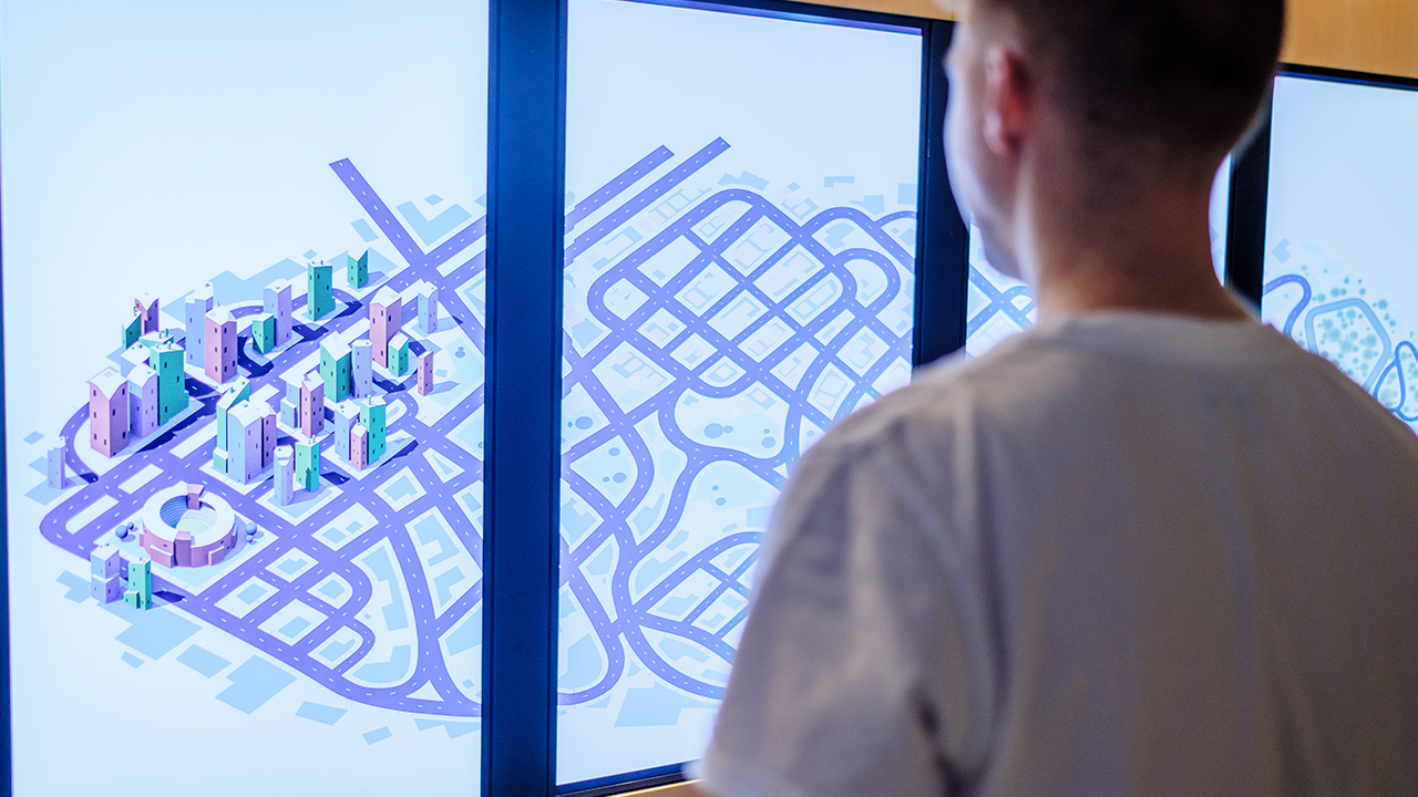 Vertical screens show a stylised city with connected roads.